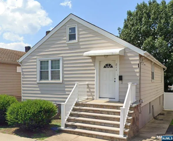 a view of a house with a yard and stairs