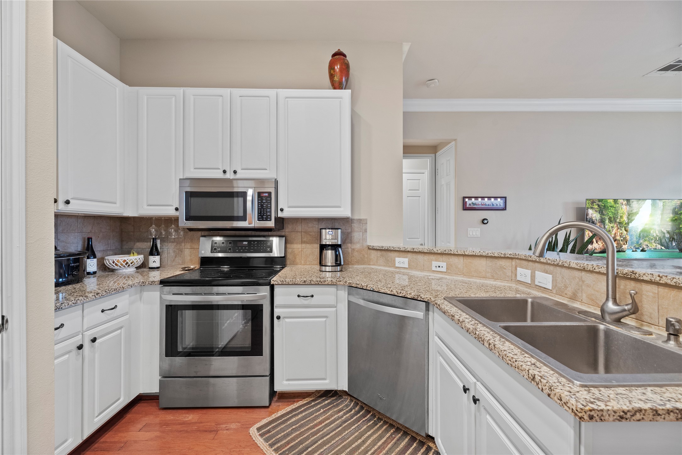2400 McCue Road, Unit 206 Houston, TX 77056 - Photo 6 of 17 Beautiful granite counters blend perfectly with the crisp white cabinets and wood flooring.
