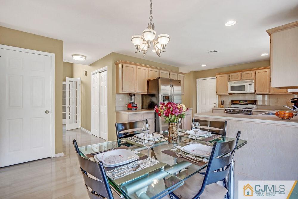 23 Mapleton Road Old Bridge, NJ 08857 - Photo 12 of 24 a open dining room with stainless steel appliances kitchen island granite countertop a dining table chairs and a refrigerator