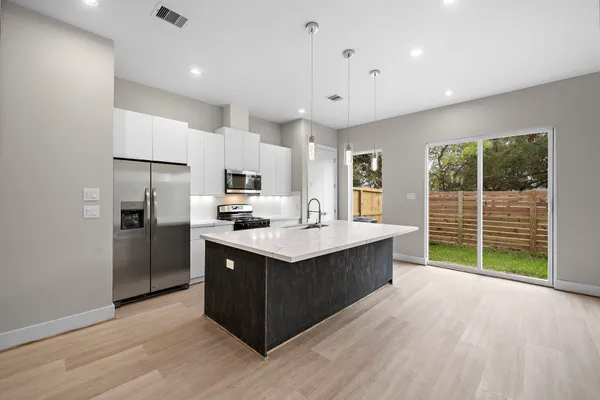 a kitchen with a sink a counter top space stainless steel appliances and a window