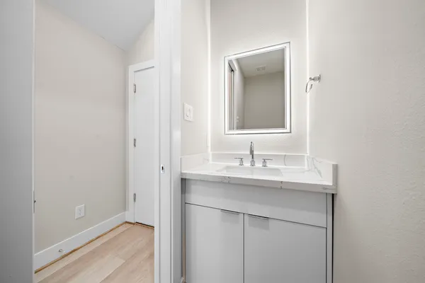a bathroom with a granite countertop sink mirror and toilet