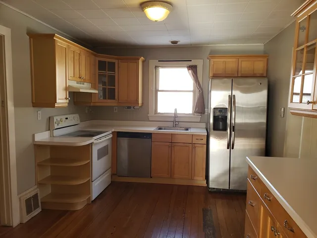 a kitchen with a refrigerator sink and cabinets