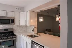 a kitchen with stainless steel appliances a stove and a microwave