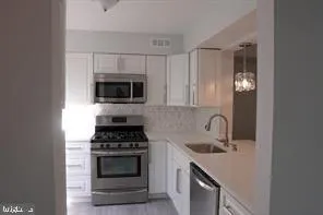 a kitchen with cabinets a stove and a microwave