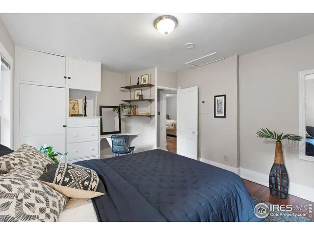 a bedroom with a bed potted plant with the view of kitchen