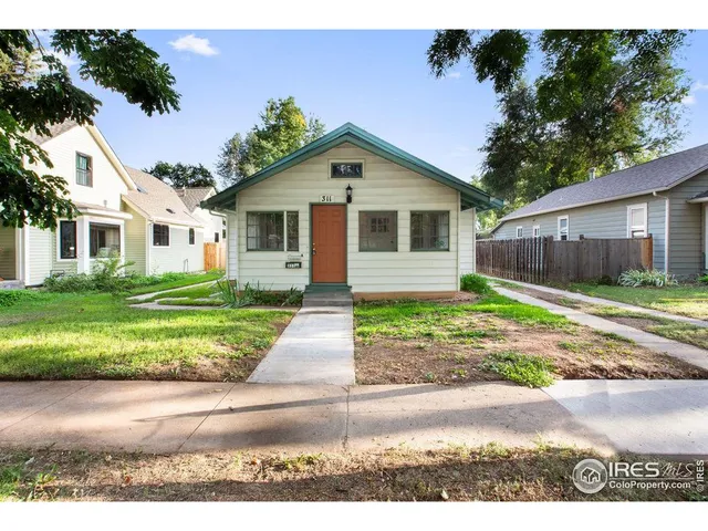 a front view of a house with a yard and potted plants