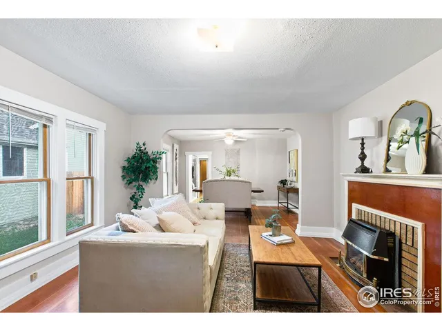 a living room with furniture a fireplace and a window
