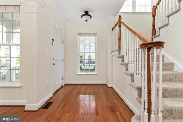 a view of hallway with wooden floor and stairs