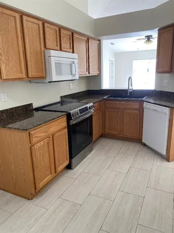 a kitchen with stainless steel appliances granite countertop a stove a sink and a microwave