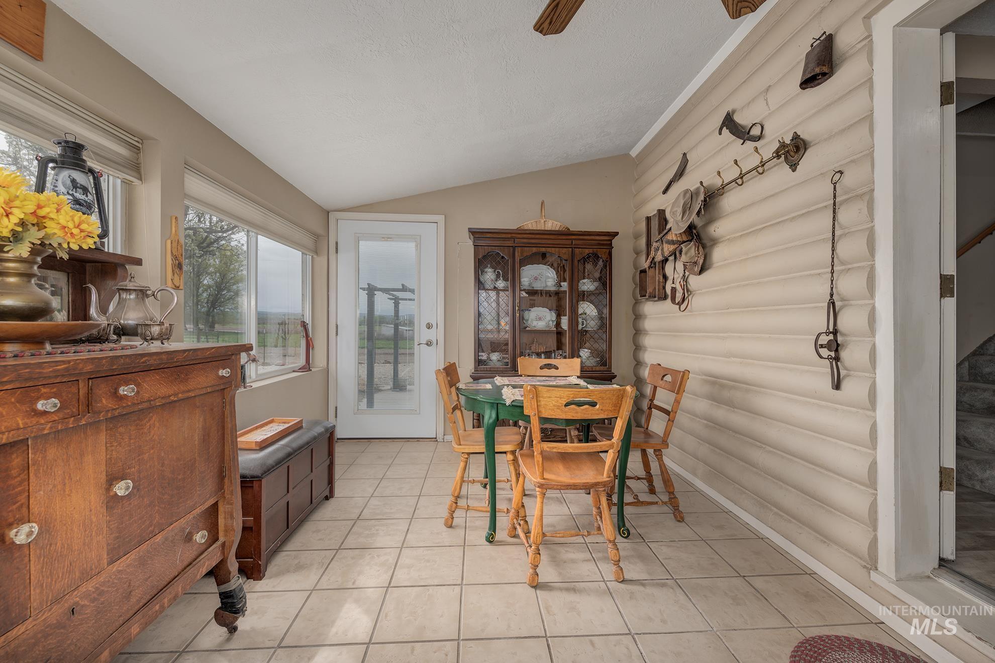 1363 Ross Road Weiser, ID 83672 - Photo 11 of 47 Dining space featuring vaulted ceiling, a ceiling fan, and light tile patterned flooring