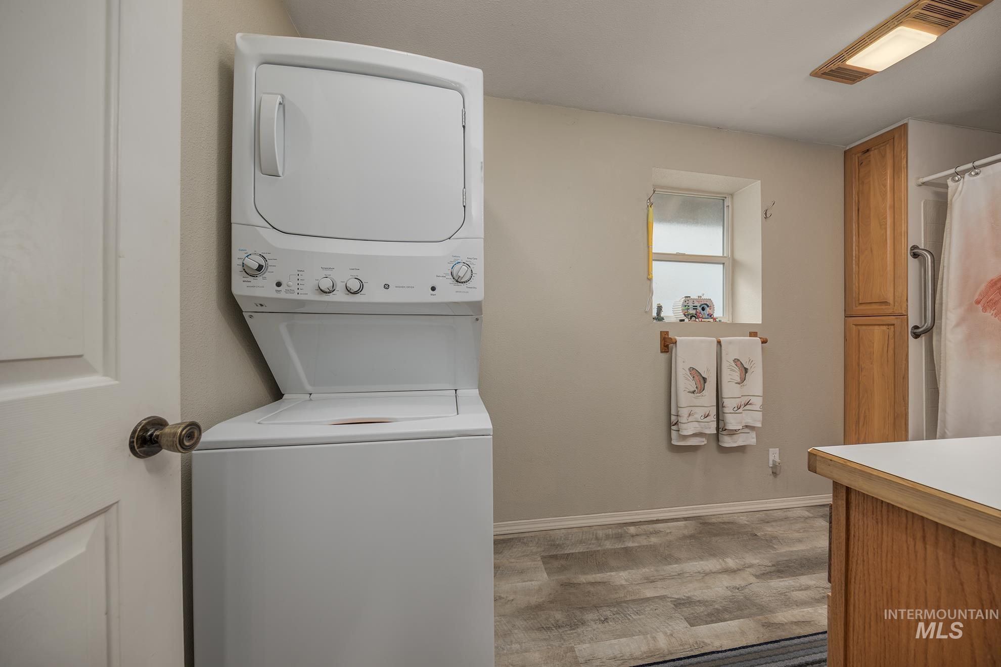 1363 Ross Road Weiser, ID 83672 - Photo 14 of 47 Laundry area with stacked washer and clothes dryer and light wood-style floors