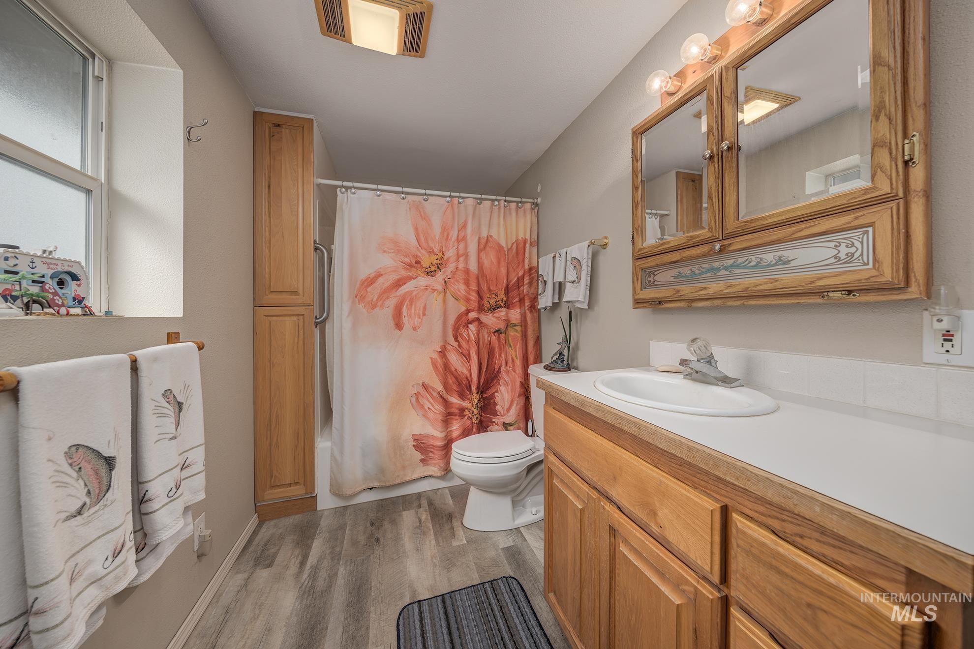 1363 Ross Road Weiser, ID 83672 - Photo 15 of 47 Bathroom with vanity, dark wood finished floors, and shower / bathtub combination with curtain