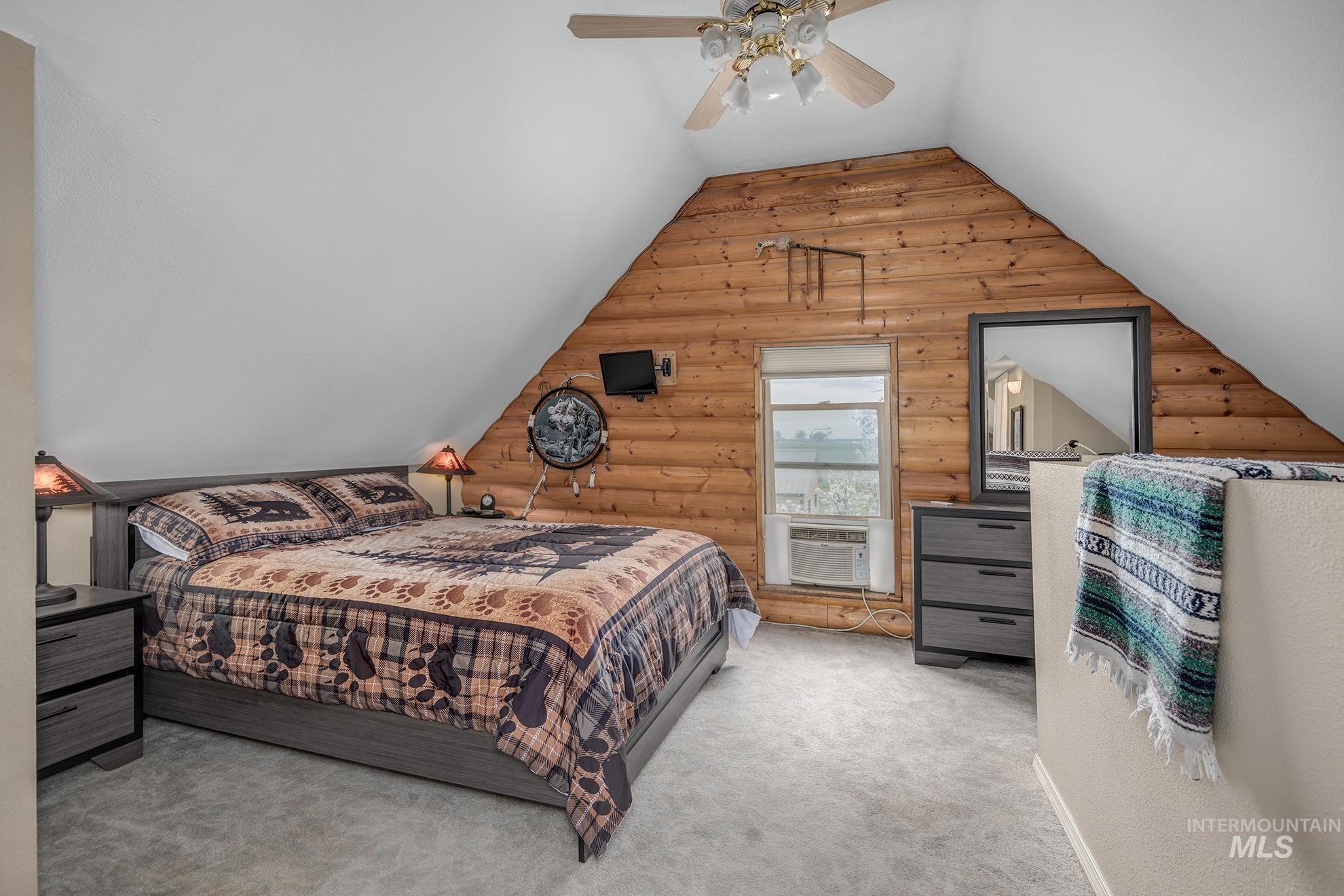 1363 Ross Road Weiser, ID 83672 - Photo 16 of 47 Bedroom with rustic walls, light carpet, ceiling fan, and lofted ceiling