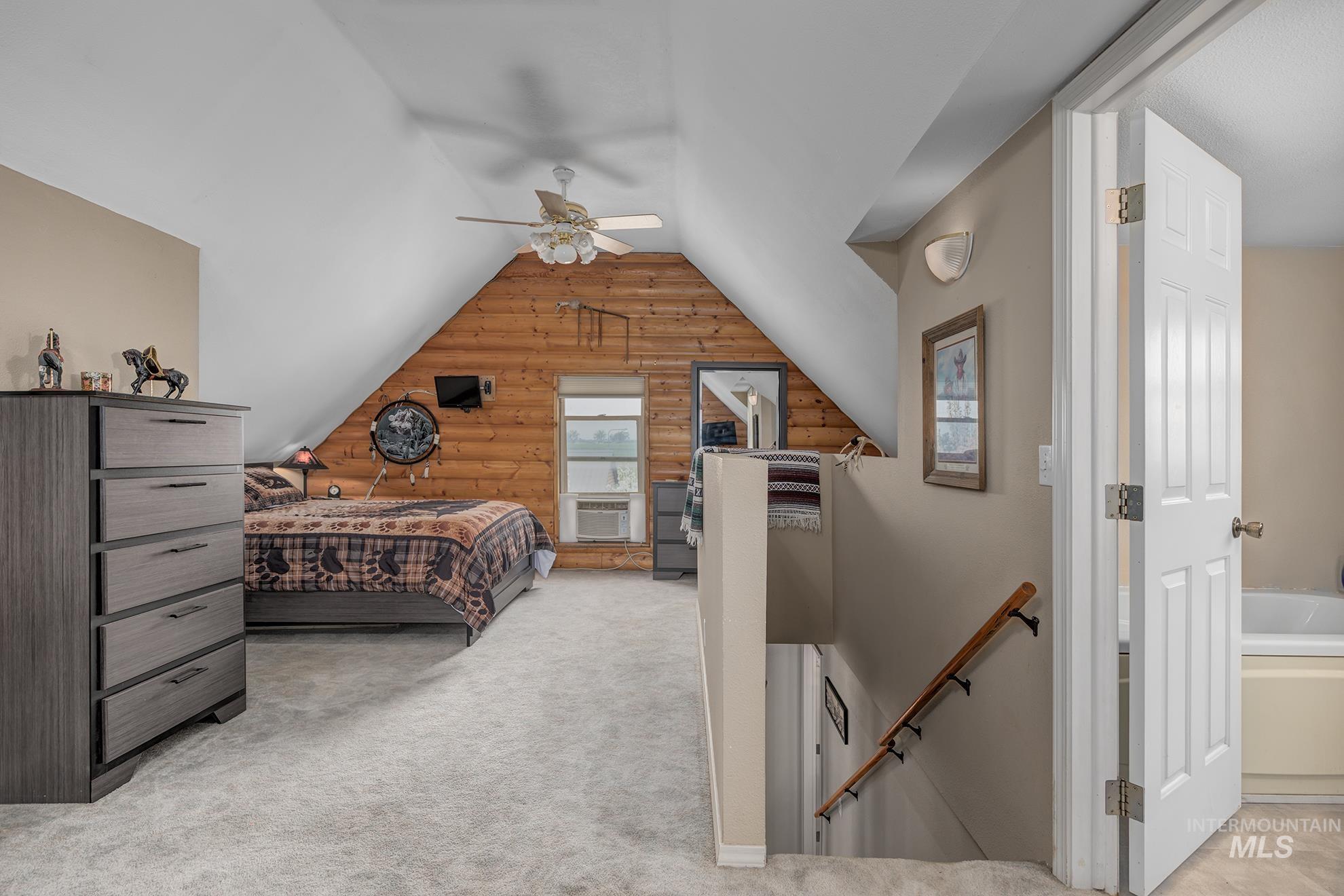 1363 Ross Road Weiser, ID 83672 - Photo 17 of 47 Bedroom featuring rustic walls, light carpet, vaulted ceiling, and ceiling fan