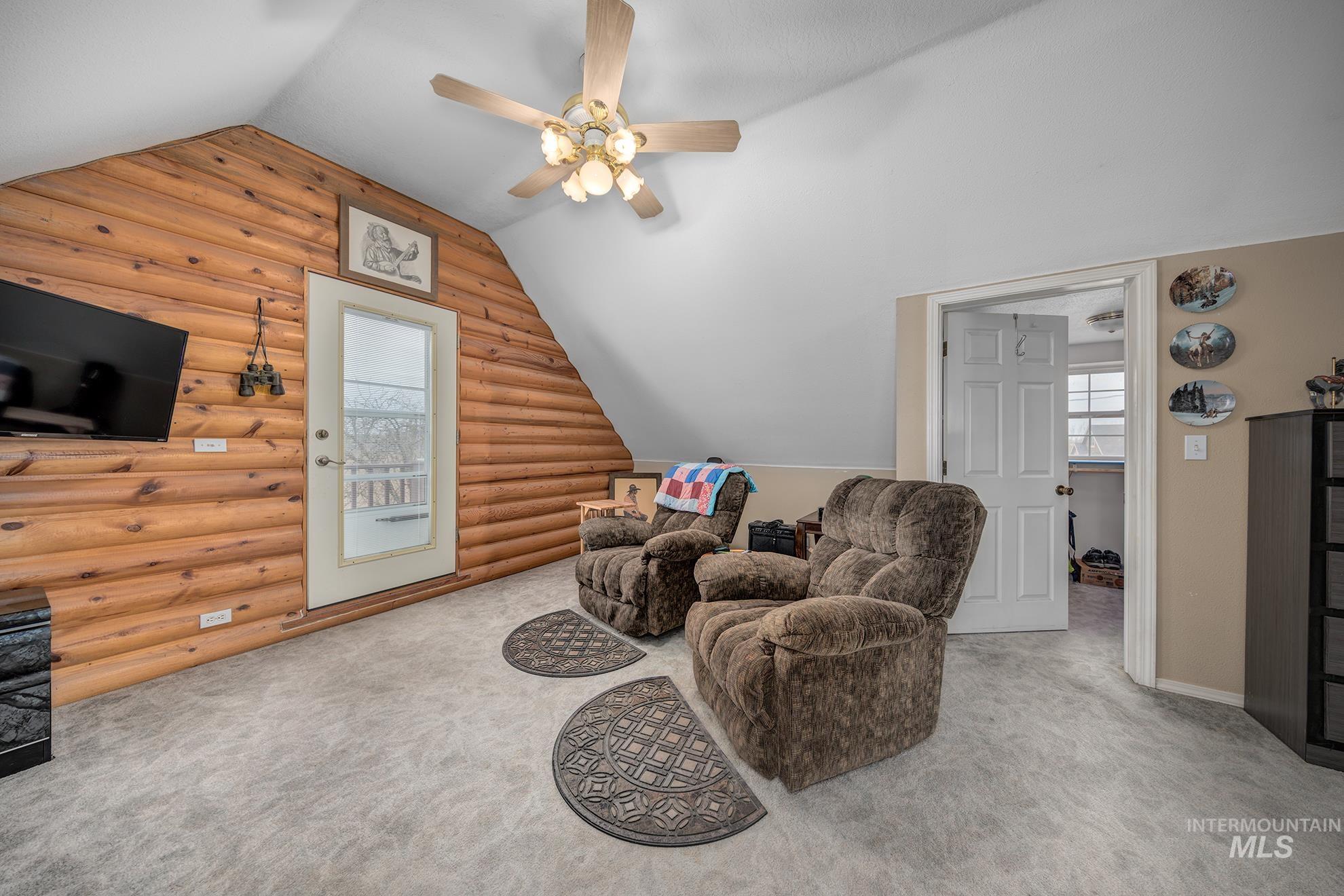 1363 Ross Road Weiser, ID 83672 - Photo 18 of 47 Sitting room with log walls, carpet floors, ceiling fan, vaulted ceiling, and healthy amount of natural light