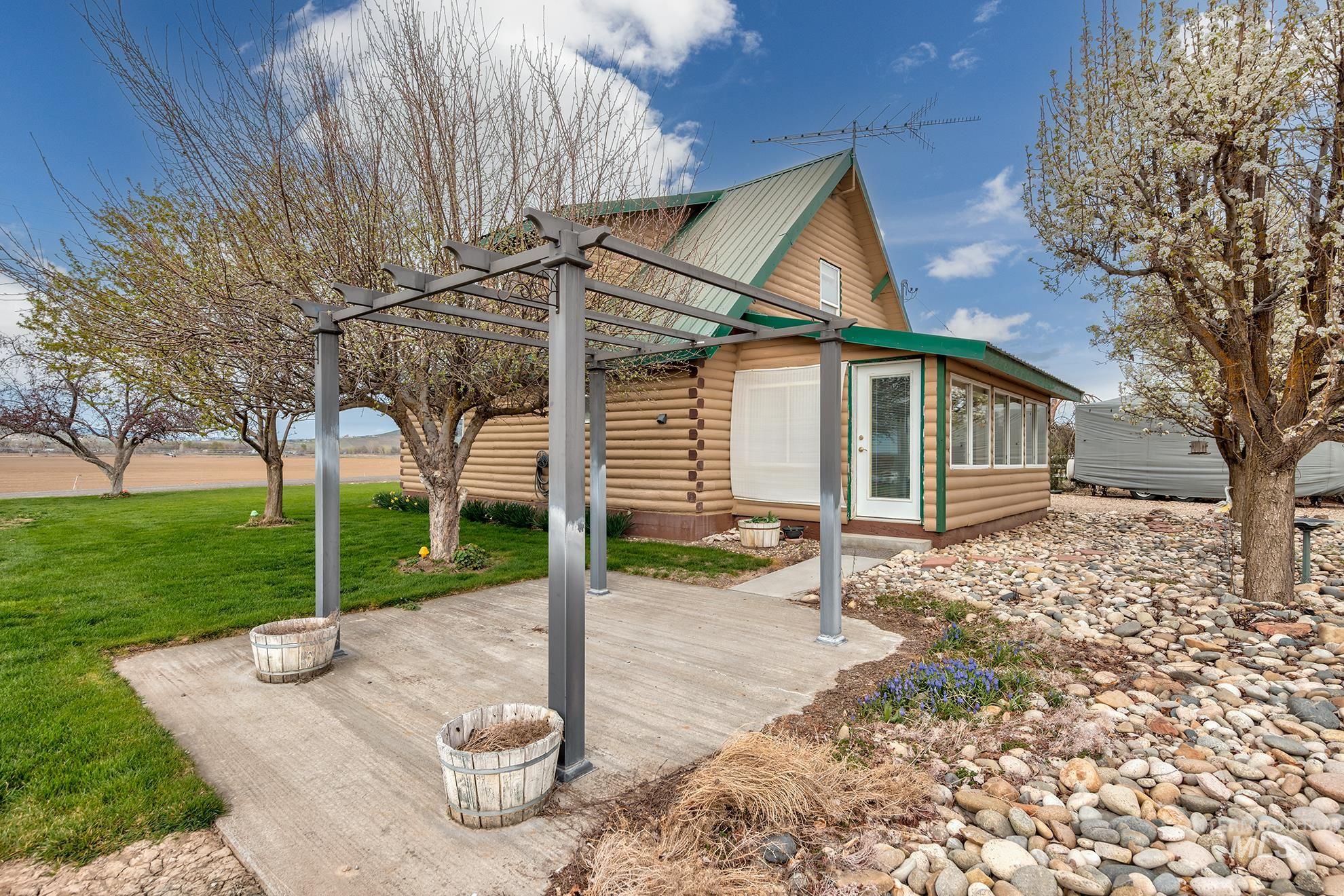 1363 Ross Road Weiser, ID 83672 - Photo 22 of 47 Exterior space featuring log exterior, a pergola, a yard, and a patio area