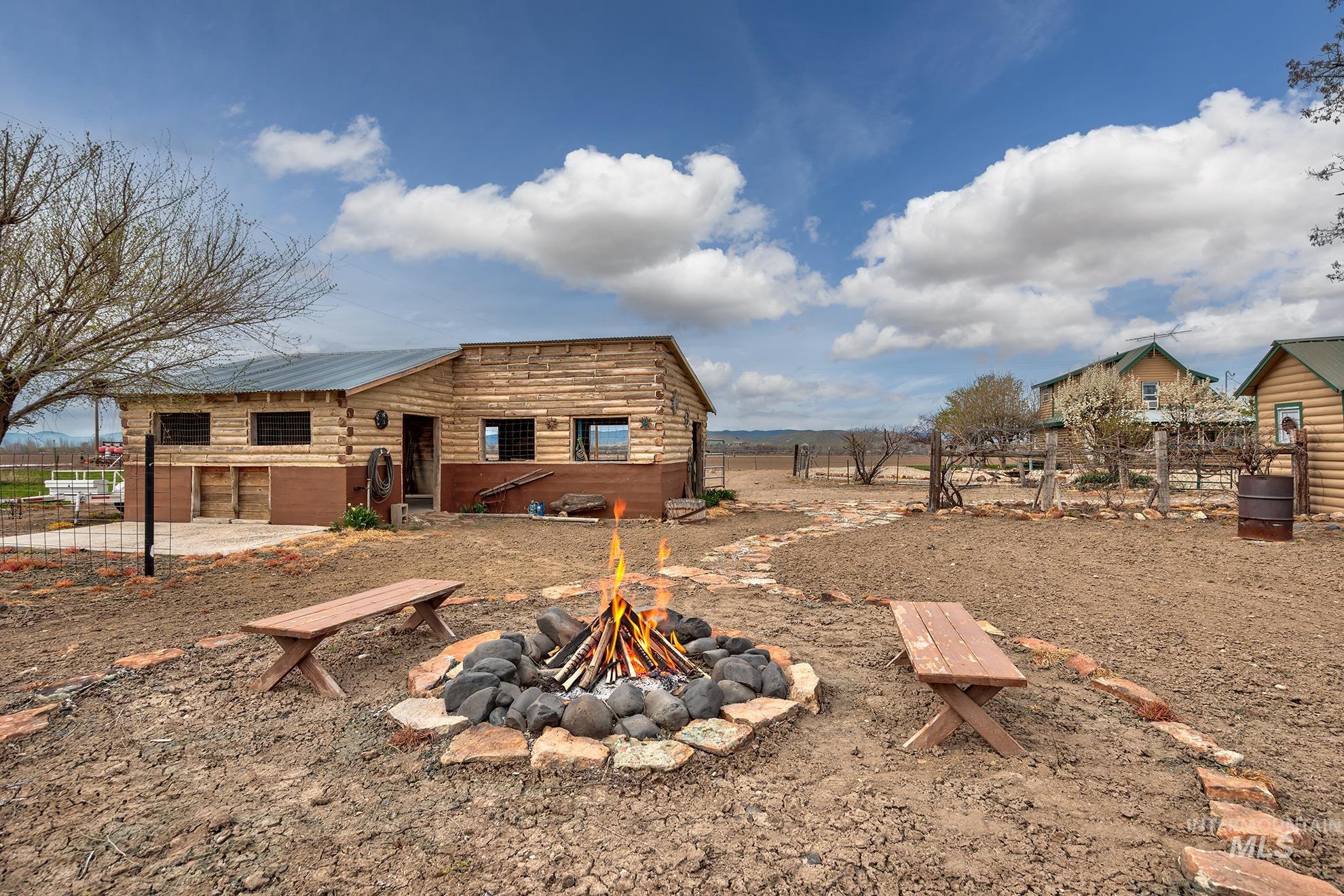 1363 Ross Road Weiser, ID 83672 - Photo 29 of 47 Rear view of property featuring a patio area, an outdoor fire pit, and a metal roof