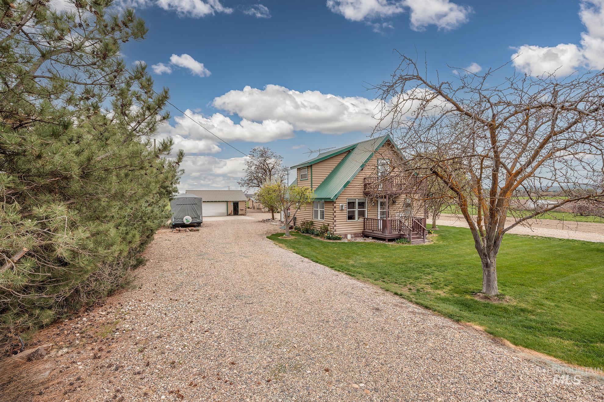 1363 Ross Road Weiser, ID 83672 - Photo 37 of 47 View of front of house featuring an outdoor structure, log siding, a front lawn, a metal roof, and a detached garage