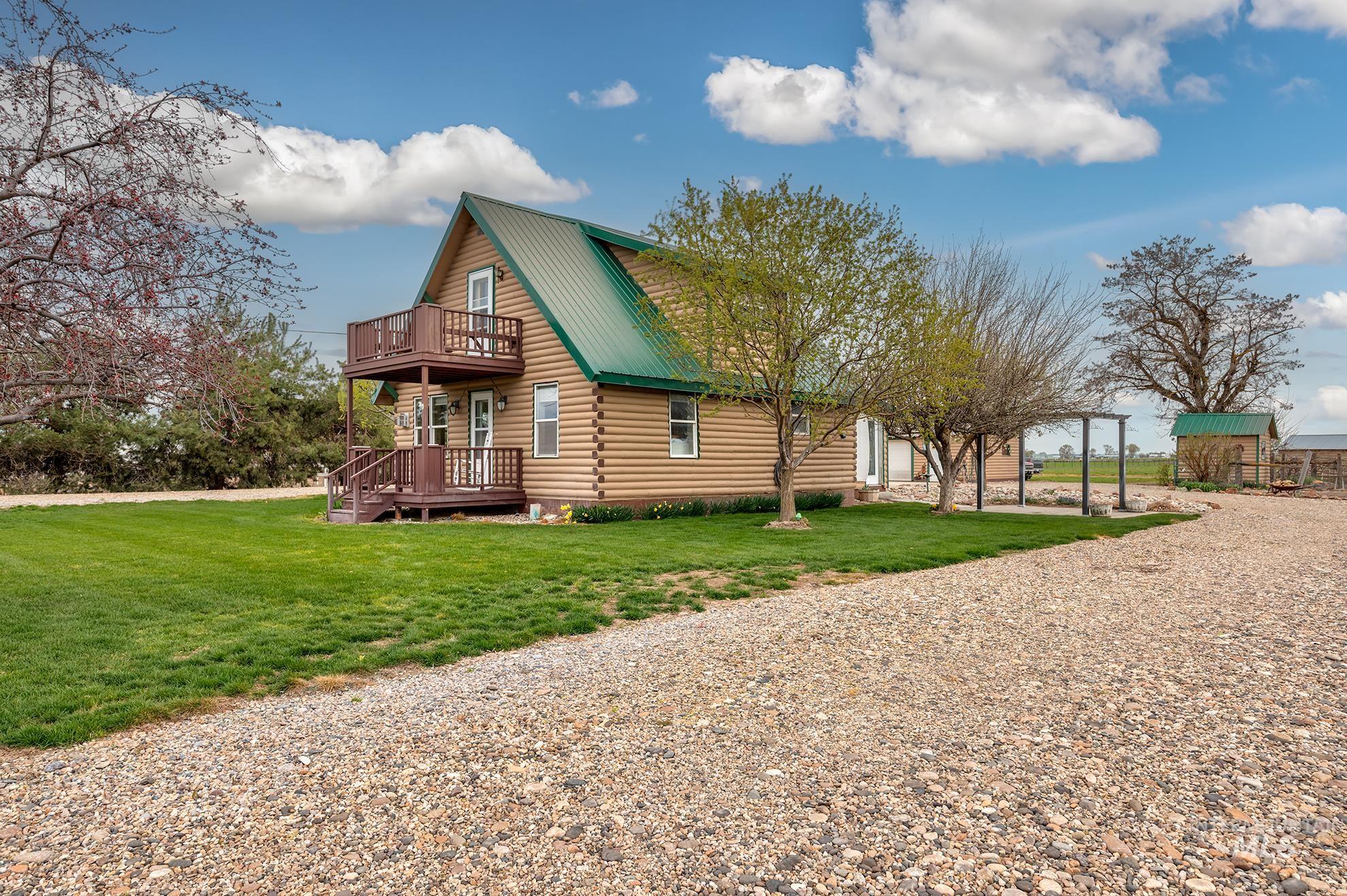 1363 Ross Road Weiser, ID 83672 - Photo 39 of 47 View of side of home featuring a metal roof, log siding, a yard, a deck, and driveway