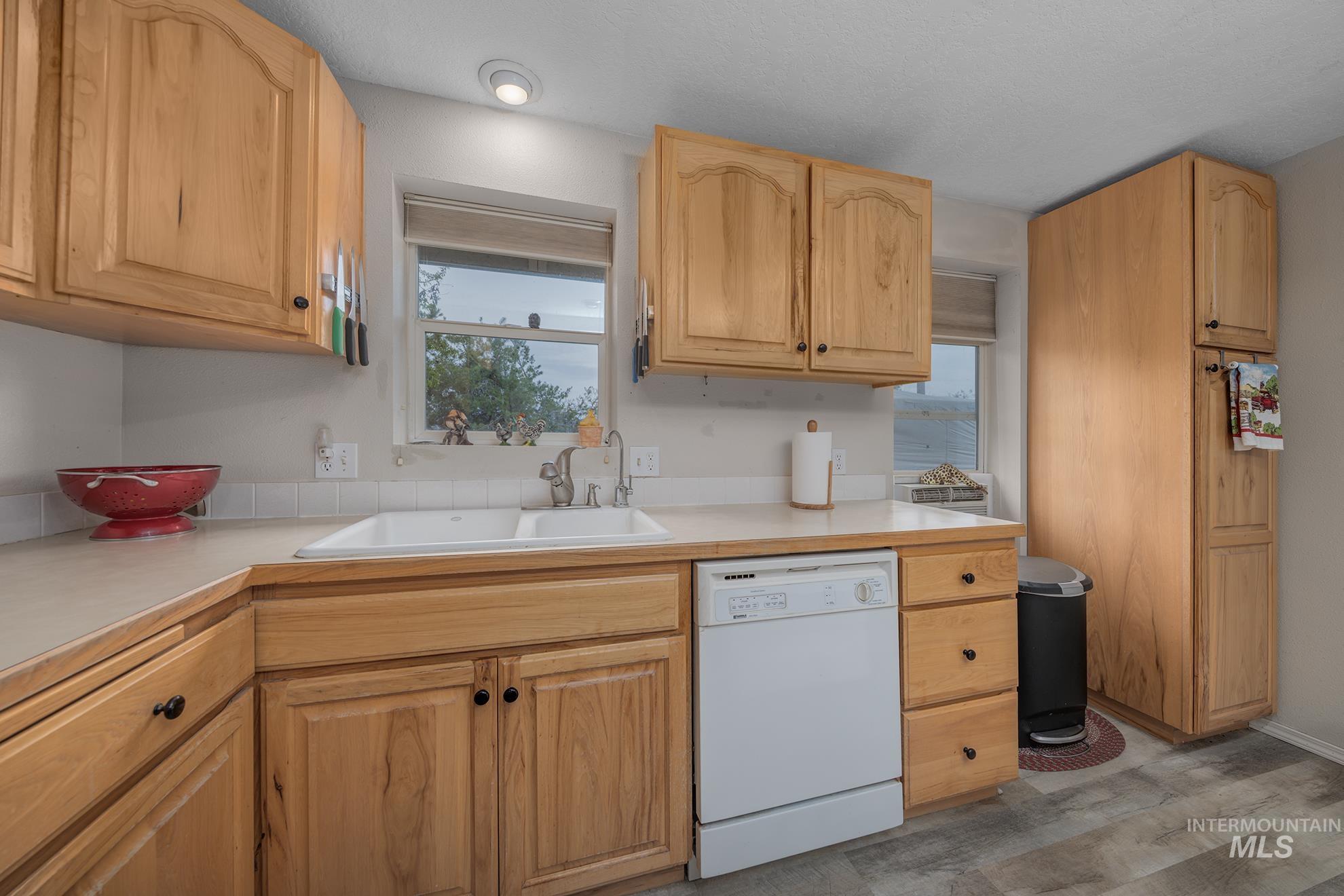 1363 Ross Road Weiser, ID 83672 - Photo 8 of 47 Kitchen with light countertops, white dishwasher, light wood-style floors, and light wood finish cabinets