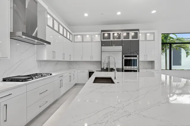 a kitchen with stainless steel appliances granite countertop a stove a sink and a refrigerator