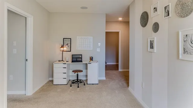 a view of a workspace with furniture and a fan