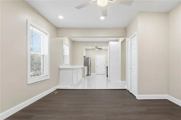 a view of an empty room with wooden floor fireplace and a window