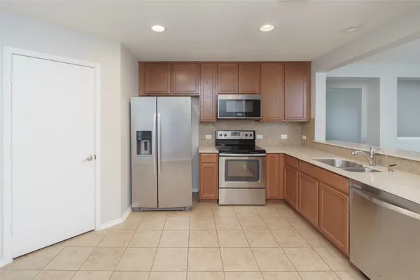 a kitchen with stainless steel appliances a refrigerator sink and microwave