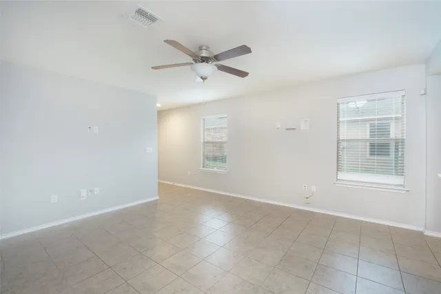 an empty room with windows and fan