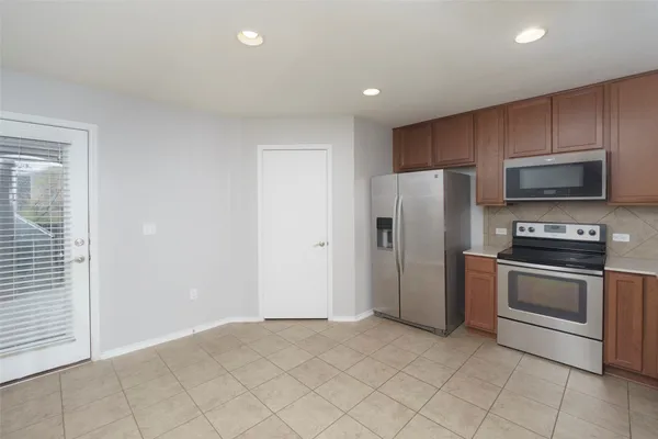 a kitchen with stainless steel appliances granite countertop a refrigerator and a stove top oven