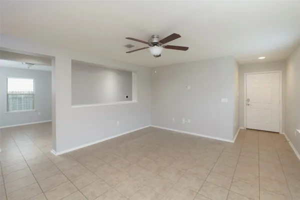 an empty room with fan and windows