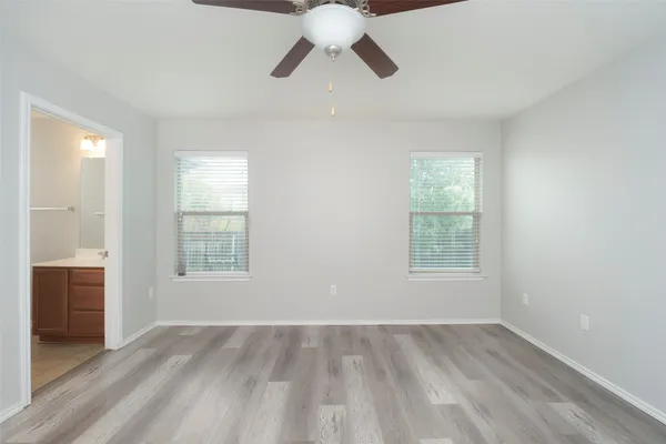 an empty room with a window and wooden floor