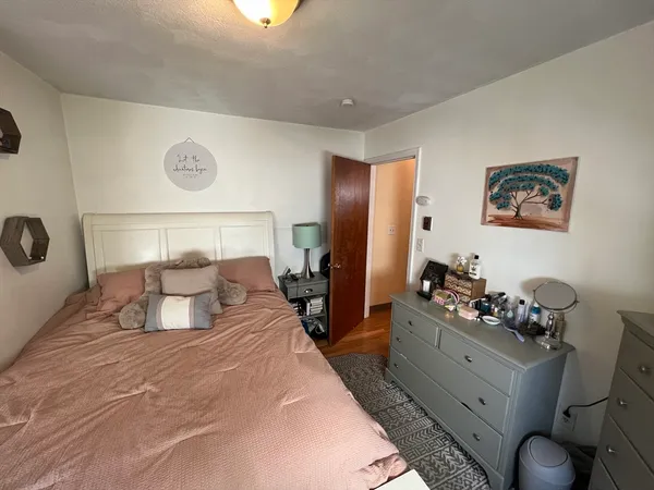 a bedroom with a bed and a flat tv screen on dresser