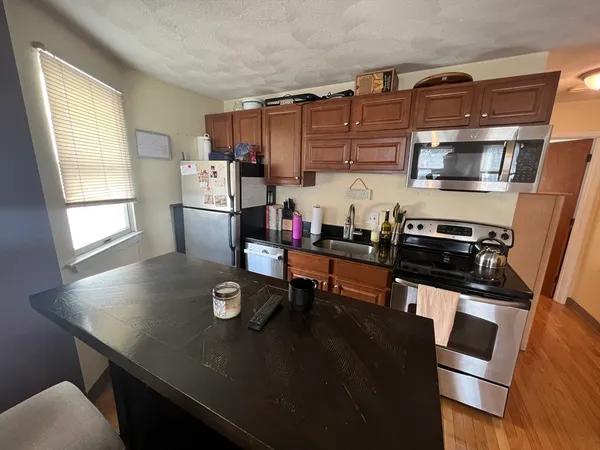 a kitchen with a sink a stove and chairs