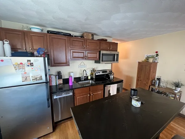 a kitchen with refrigerator cabinets and wooden floor
