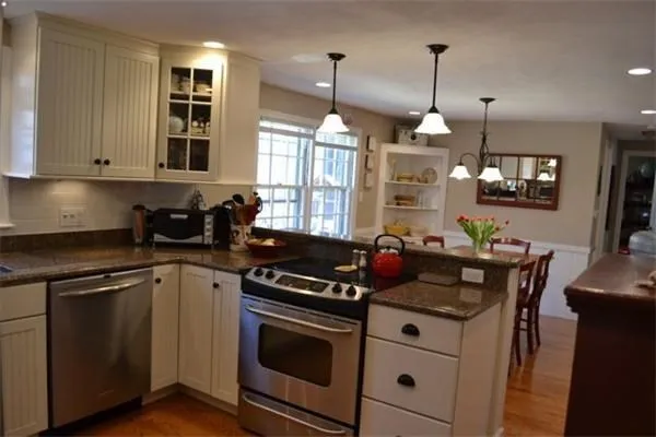 a kitchen with stainless steel appliances granite countertop a stove a sink and a refrigerator