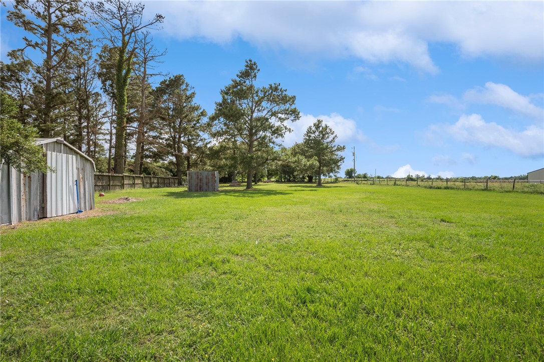 1152 McNutt Road Franklin, TX 77856 - Photo 32 of 38 a view of a grassy field with trees in the background