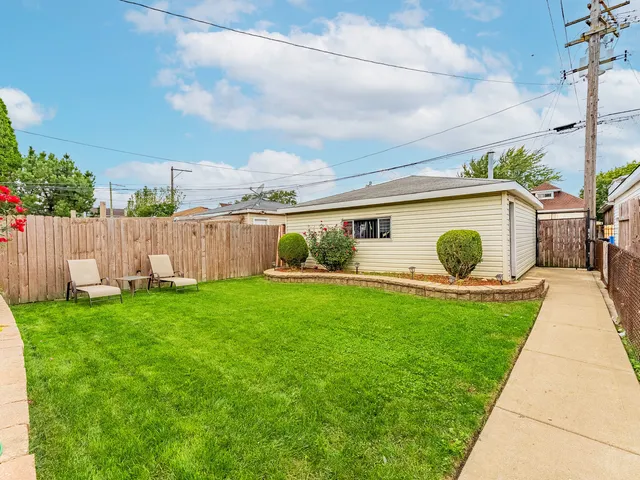 a view of a backyard with couches plants and large tree