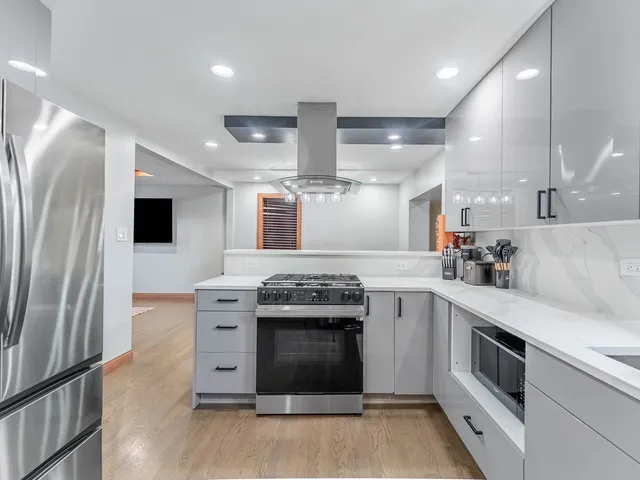 a kitchen with stainless steel appliances granite countertop a stove and a refrigerator