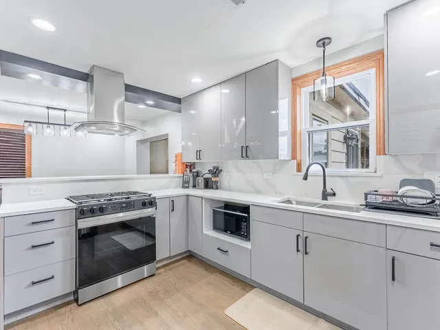 a kitchen with cabinets stainless steel appliances a sink and a window