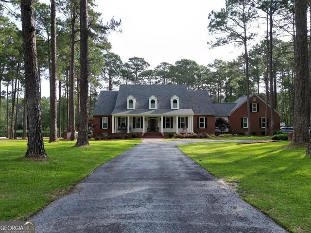 a view of a big yard in front of a house with large trees