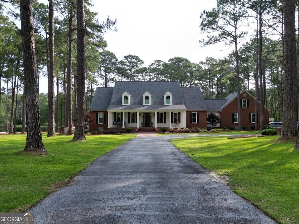 a view of a big yard in front of a house with large trees