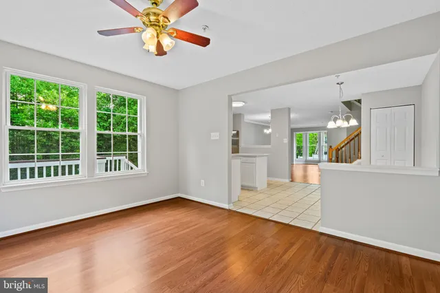 a view of an empty room with window and wooden floor