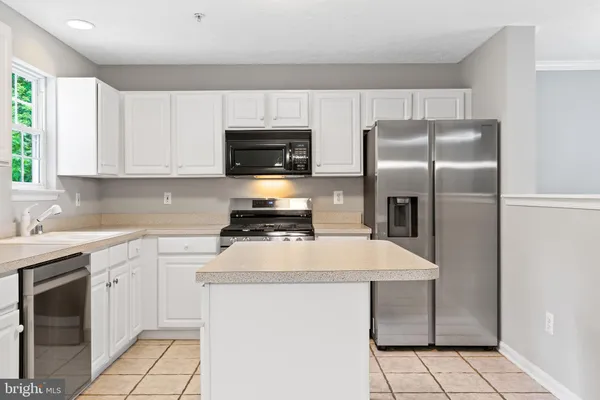 a kitchen with a sink a microwave a refrigerator and cabinets