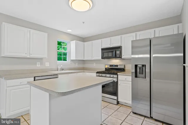 a kitchen with a refrigerator a sink a stove a microwave and cabinets