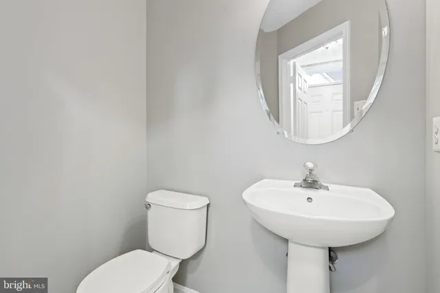 a bathroom with a toilet a sink and a mirror