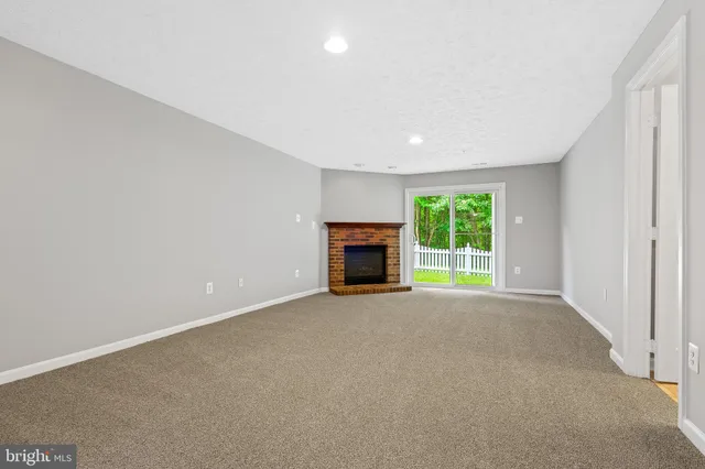 an empty room with a fireplace and window