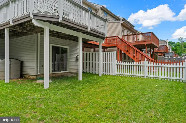 a view of a house with a small yard and wooden fence