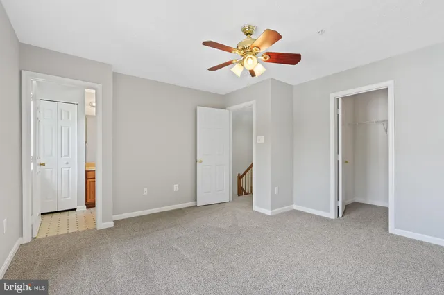 a view of an empty room with window and a chandelier fan