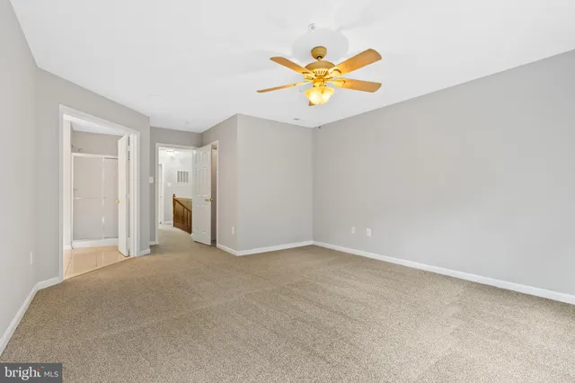 a view of a livingroom with a chandelier fan and a kitchen